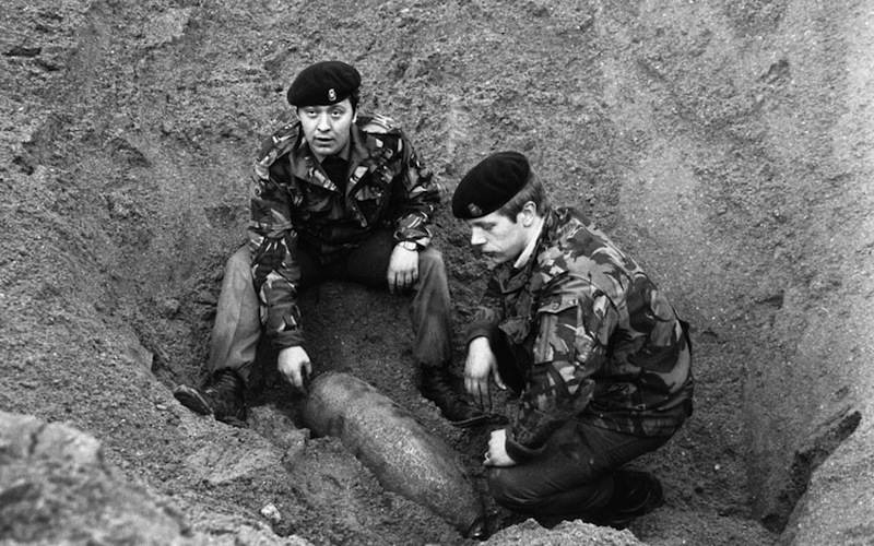 Workers inspecting an unexploded bomb from WW2 discovered next to the station