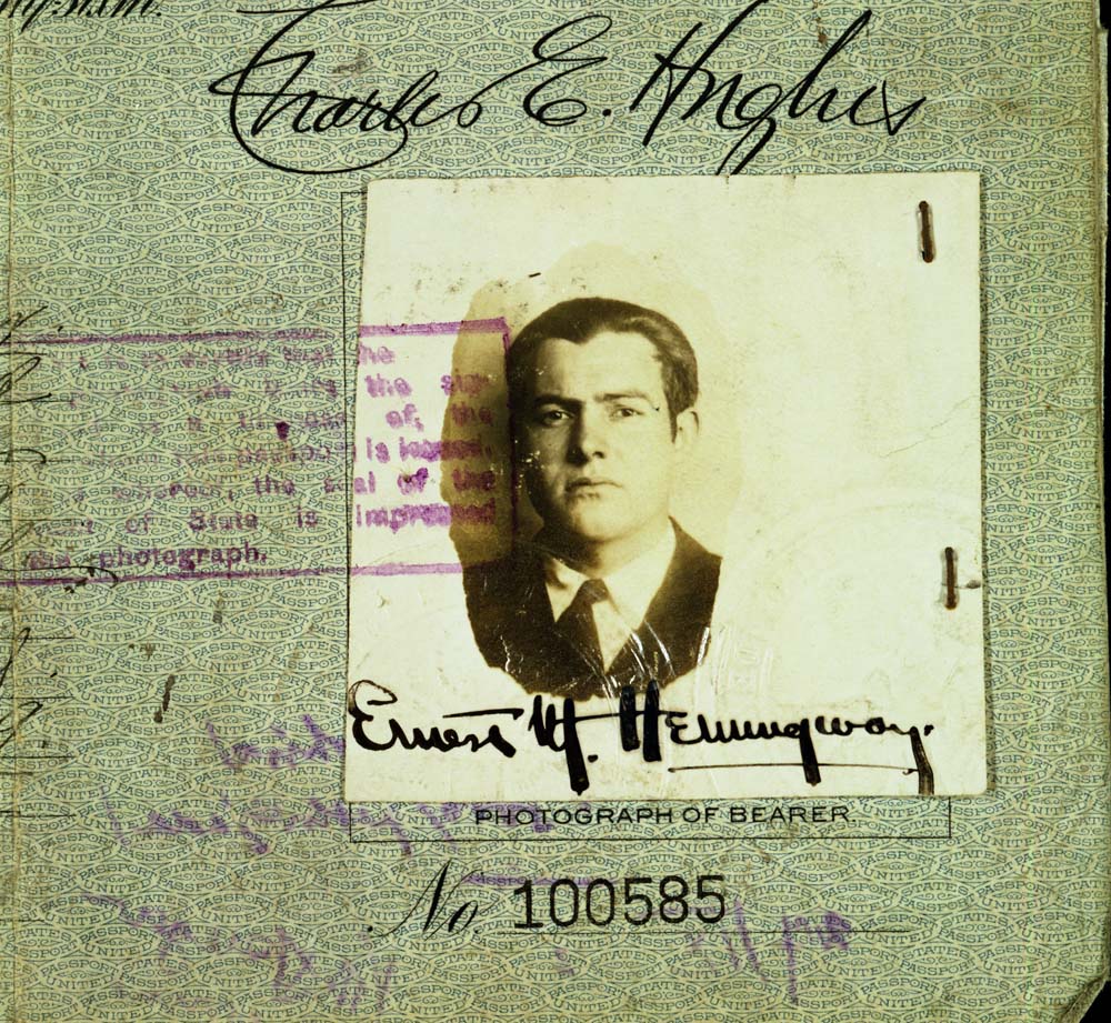 EH-C6163D 1921 Detail of photograph from Ernest Hemingway's 1921 United States Passport, with his signature across the bottom of the image. Passport number 100585, with stamp and other writing at edges. Photograph in the Ernest Hemingway Collection of the John F. Kennedy Presidential Library and Museum, Boston. Scanned from 4x5" copy negative by LAA DAMS 2B.