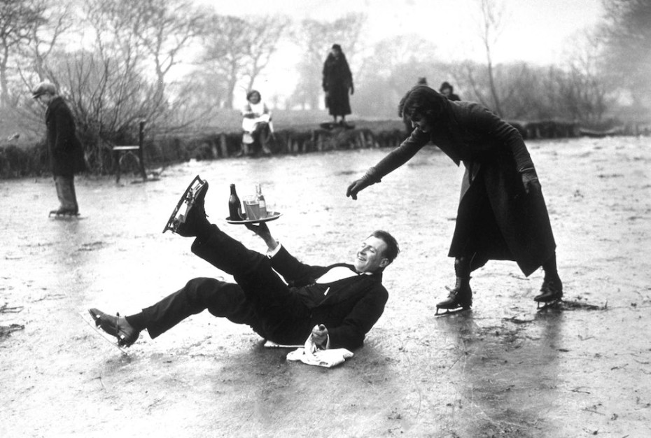 13th February 1936: A skating waiter slips on the ice, drinks tray in hand, but doesn't spill a drop! (Photo by E. Dean/Topical Press Agency/Getty Images)