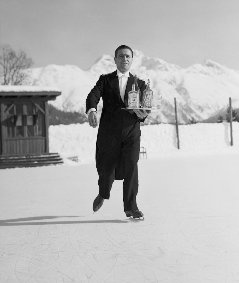 8th January 1938: A waiter skates across the ice at St. Moritz carrying a tray of drinks for his customers. (Photo by Horace Abrahams/Fox Photos/Getty Images)